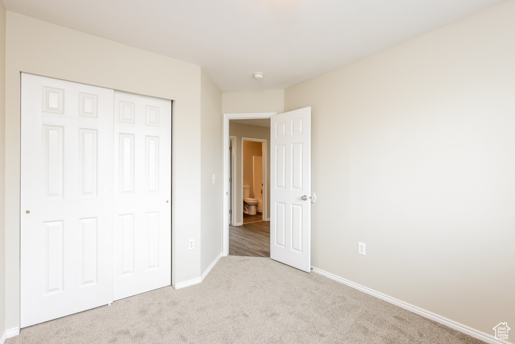 Unfurnished bedroom with baseboards, a closet, and carpet flooring