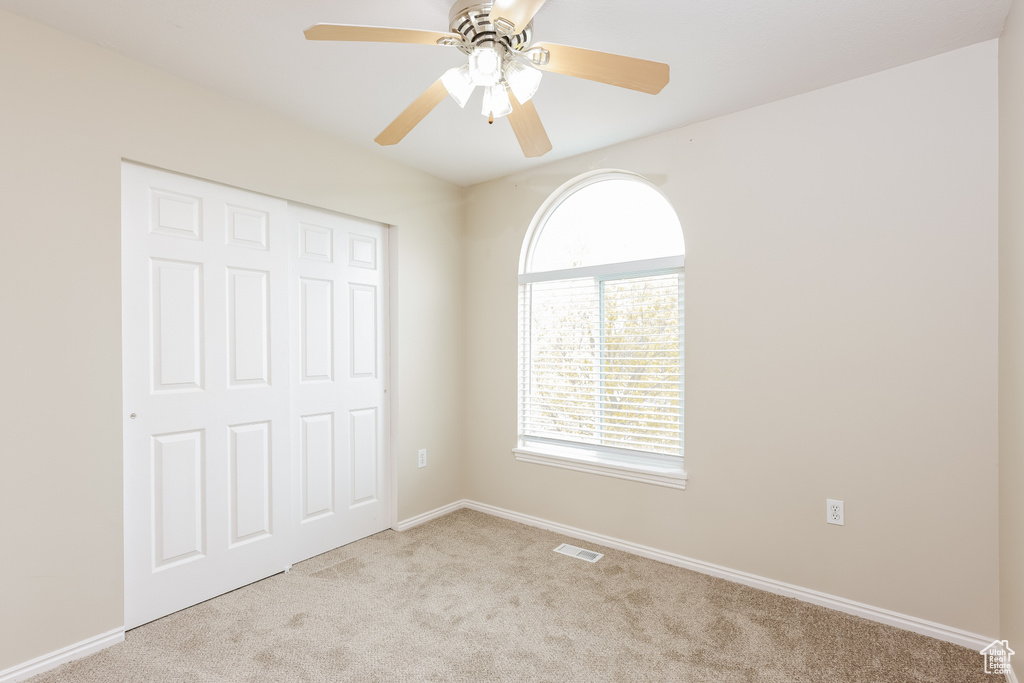 Unfurnished bedroom featuring visible vents, baseboards, a closet, carpet, and a ceiling fan