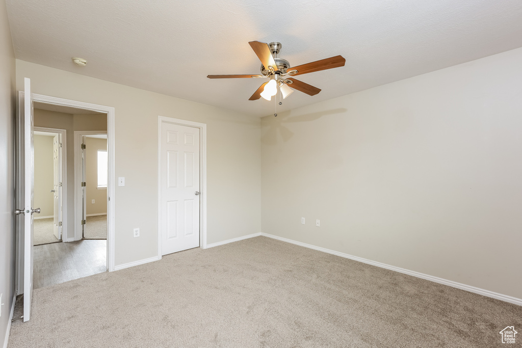 Unfurnished bedroom featuring a ceiling fan, carpet floors, and baseboards