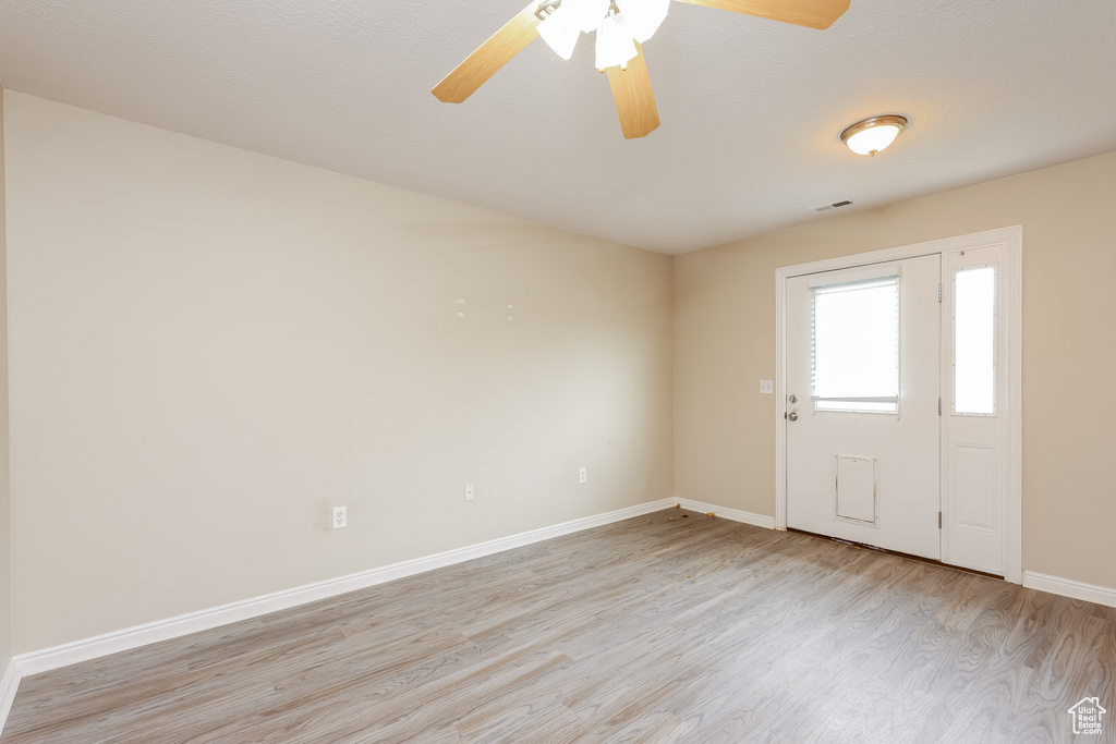 Entryway featuring visible vents, ceiling fan, baseboards, and light wood-style floors
