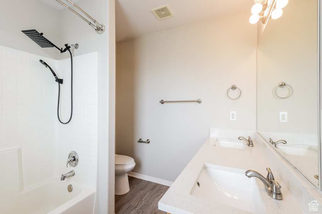 Full bath featuring wood finished floors, visible vents, toilet, and a sink