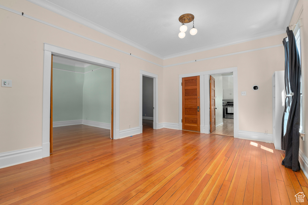 Interior space featuring crown molding, baseboards, and light wood-type flooring