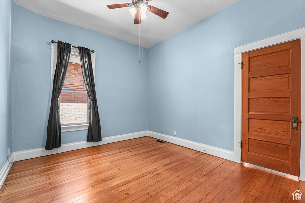 Empty room with baseboards, a ceiling fan, and light wood finished floors