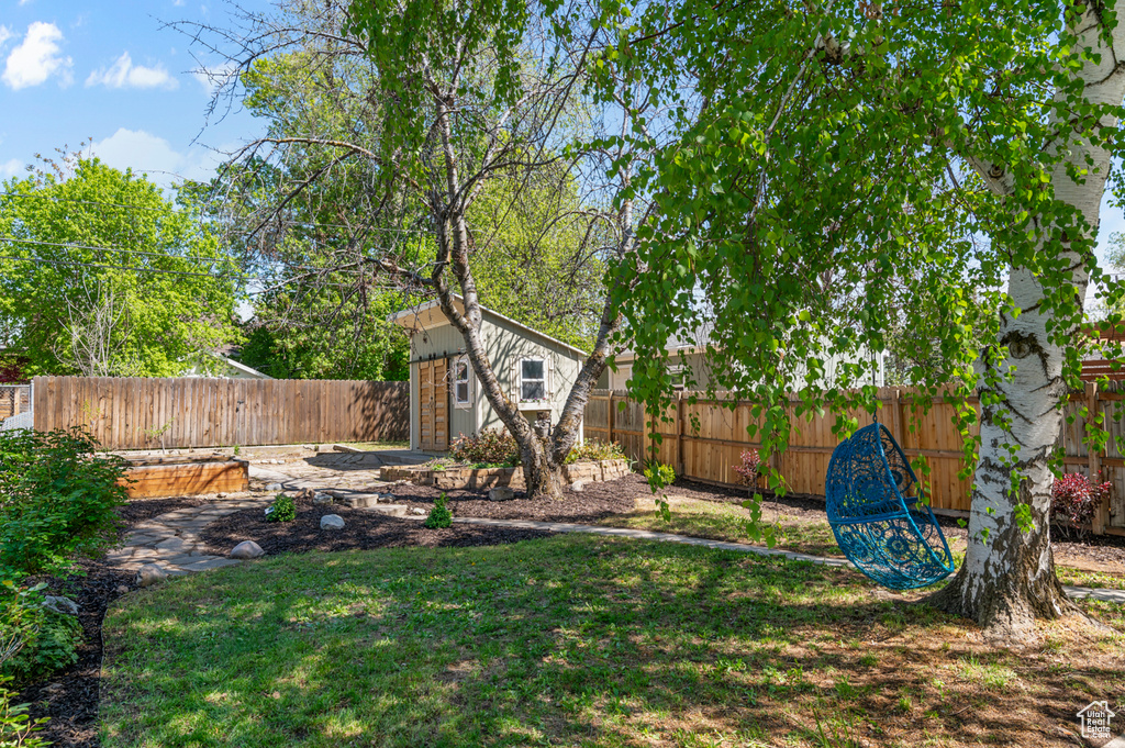 View of yard with a fenced backyard, an outbuilding, and a shed