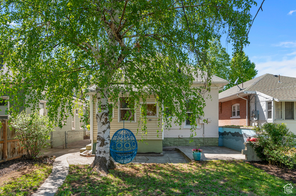 View of front of home with fence, a front yard, a patio area, and brick siding