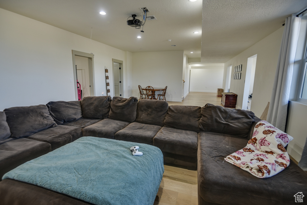 Living room featuring recessed lighting, light wood-style flooring, and visible vents