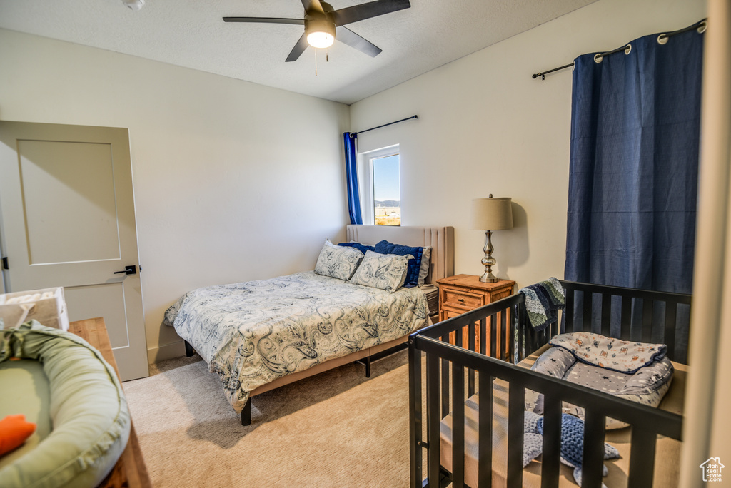 Bedroom featuring ceiling fan and carpet