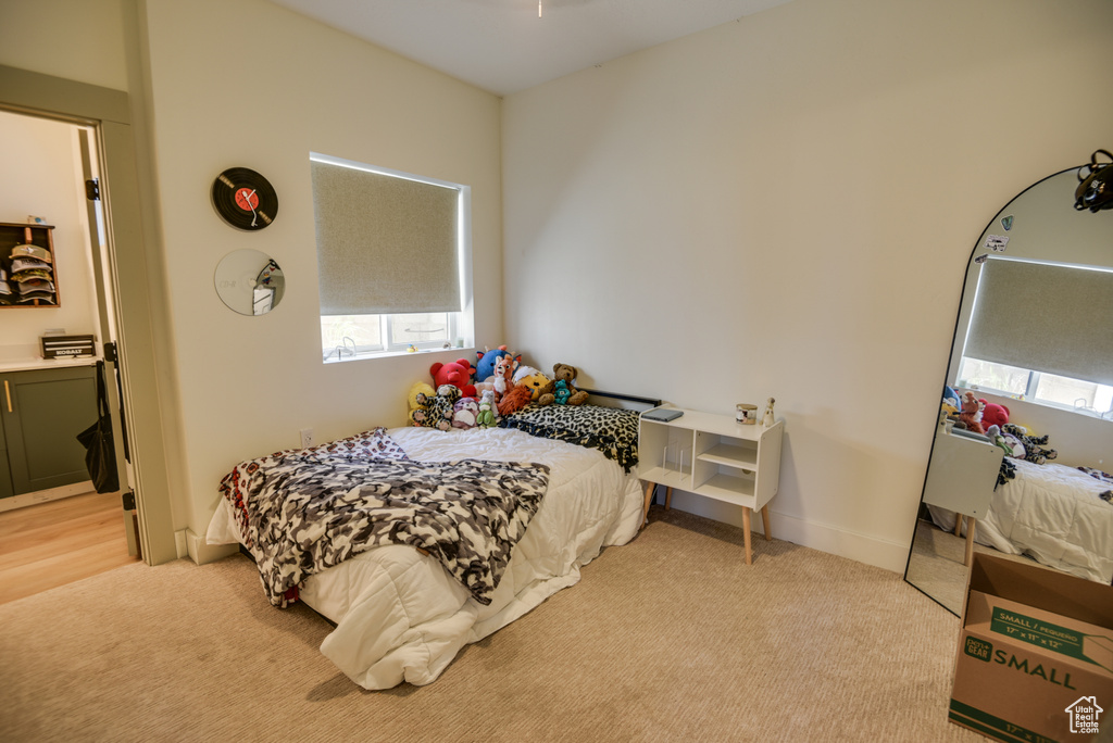 Bedroom featuring multiple windows and light colored carpet