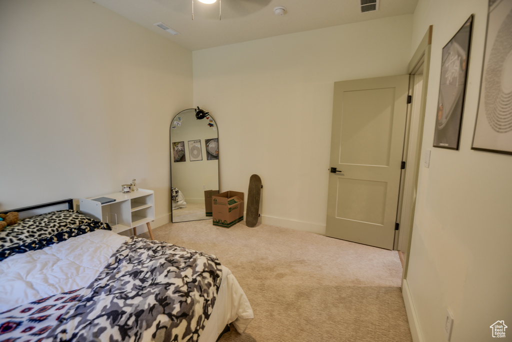 Bedroom with carpet floors, baseboards, visible vents, and ceiling fan