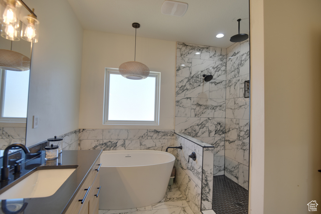 Bathroom with walk in shower, tile walls, and a healthy amount of sunlight