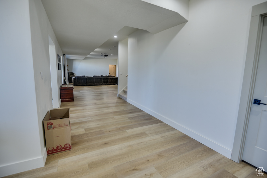 Hallway with recessed lighting, baseboards, stairway, and light wood-style floors