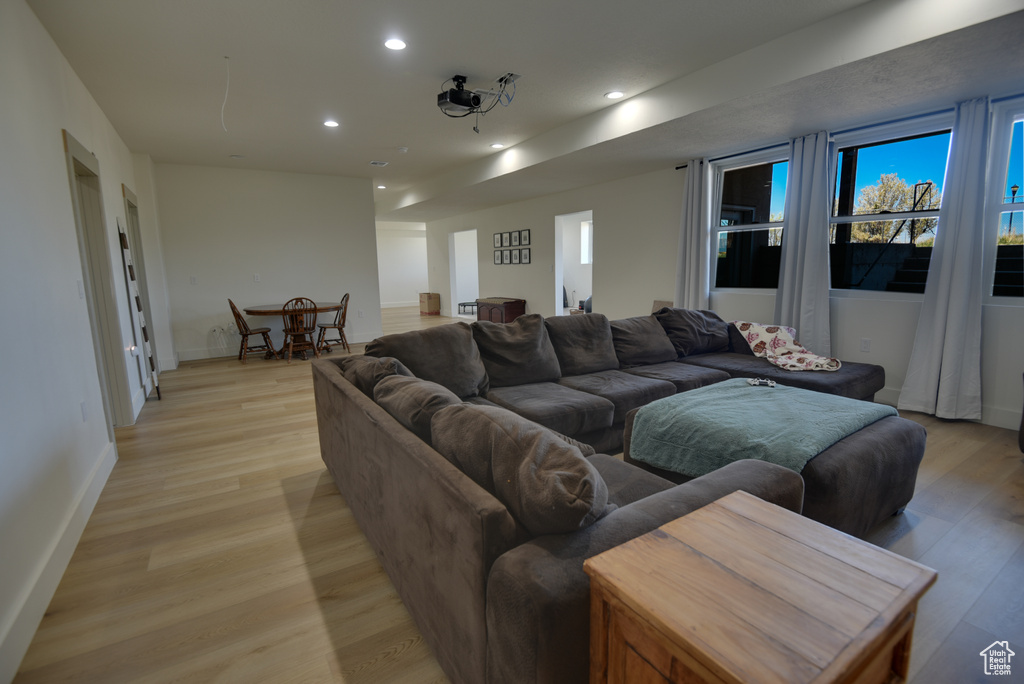 Living area with recessed lighting, light wood finished floors, and baseboards