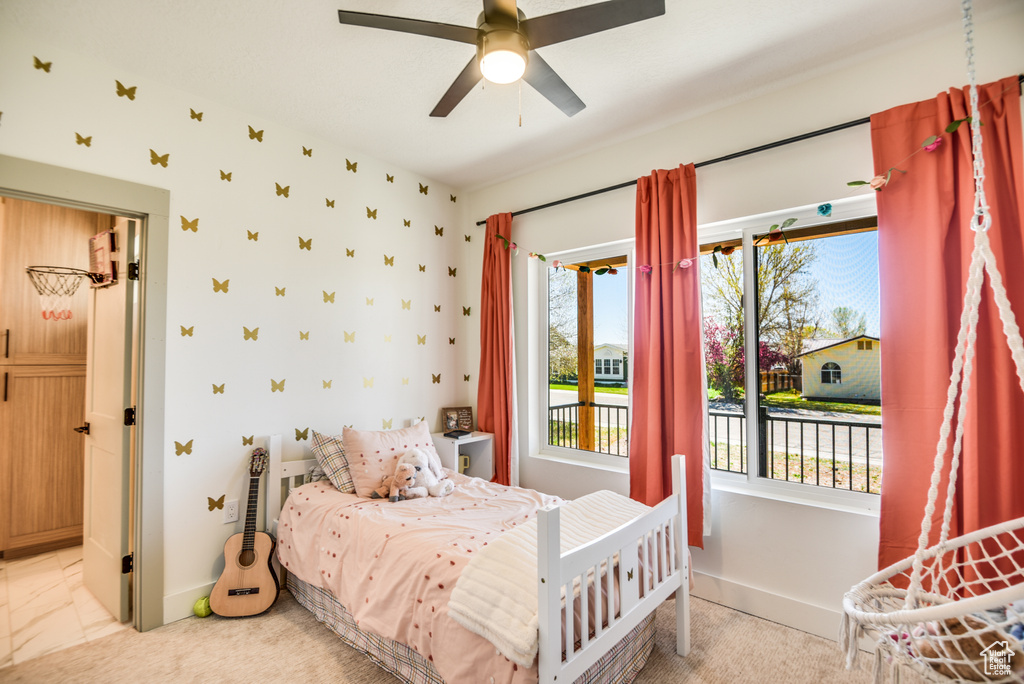 Bedroom with a ceiling fan, baseboards, multiple windows, and access to exterior
