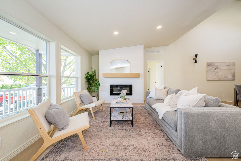Living room featuring visible vents, lofted ceiling, baseboards, recessed lighting, and a large fireplace