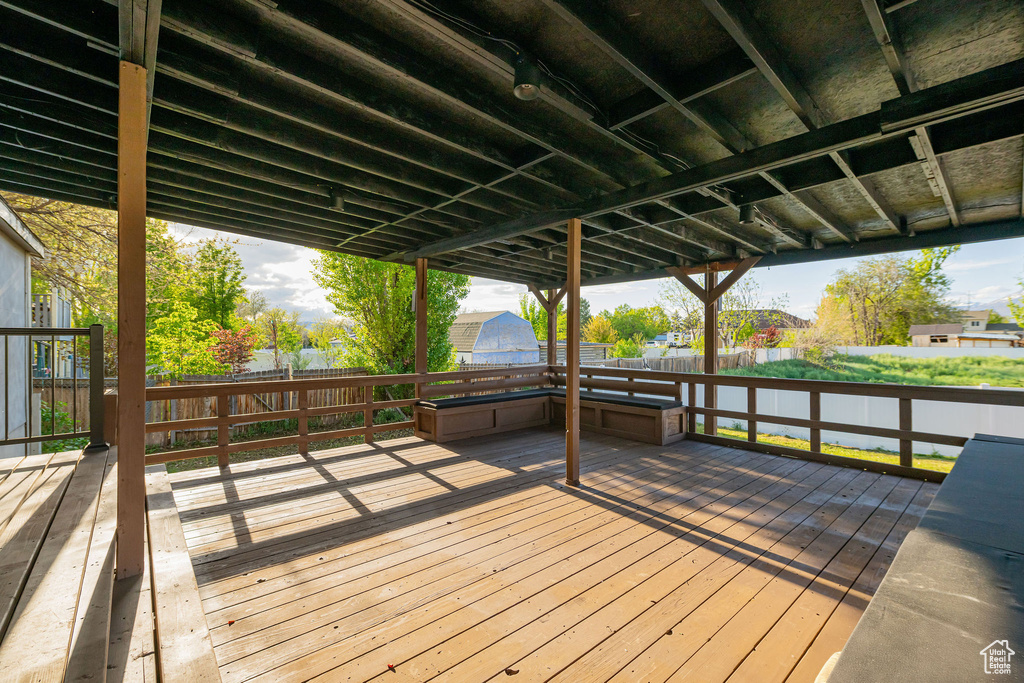 Wooden terrace with a fenced backyard