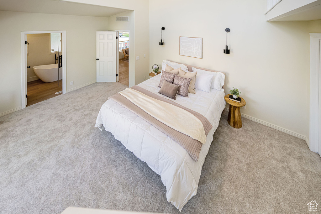 Bedroom with baseboards, light carpet, connected bathroom, and visible vents