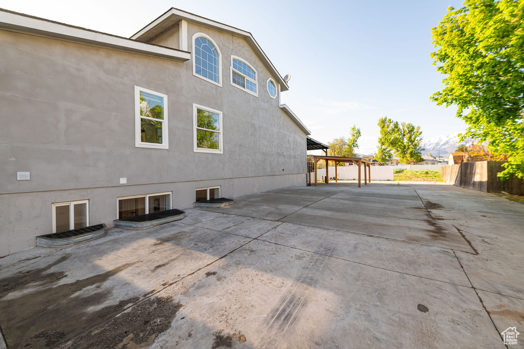 View of side of home with a pergola, fence, a patio area, and stucco siding