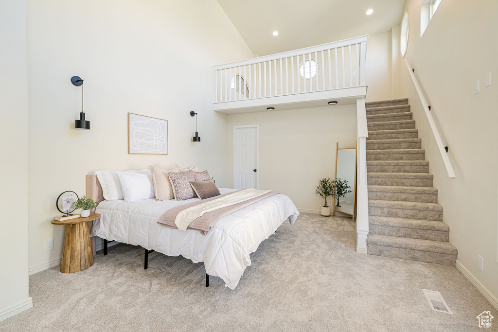 Carpeted bedroom with recessed lighting, a high ceiling, visible vents, and baseboards