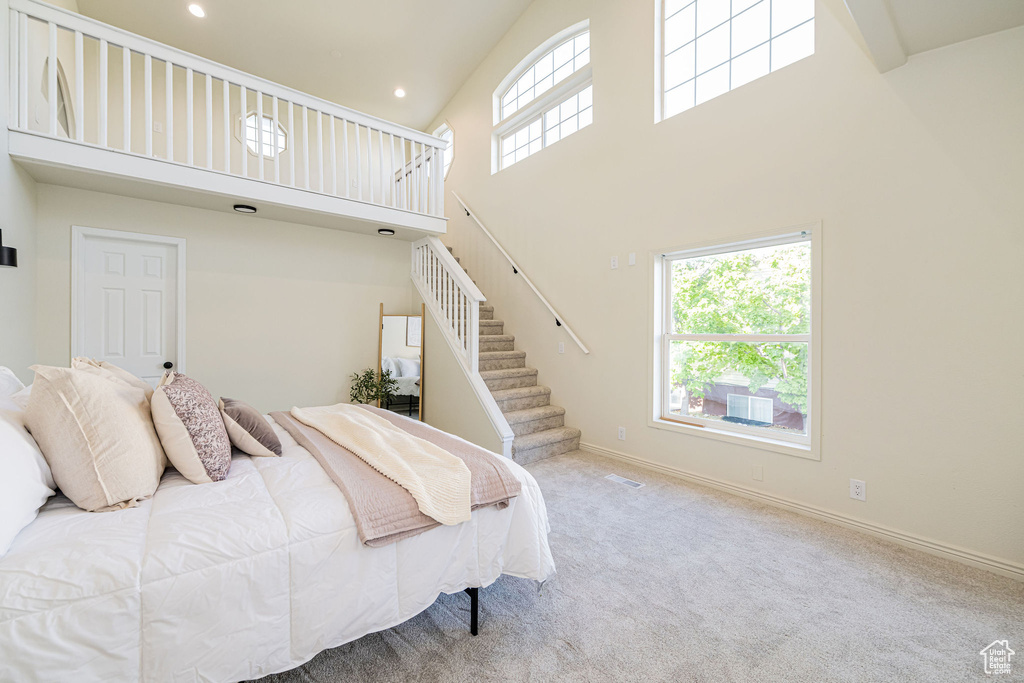 Bedroom with carpet floors, recessed lighting, high vaulted ceiling, and visible vents