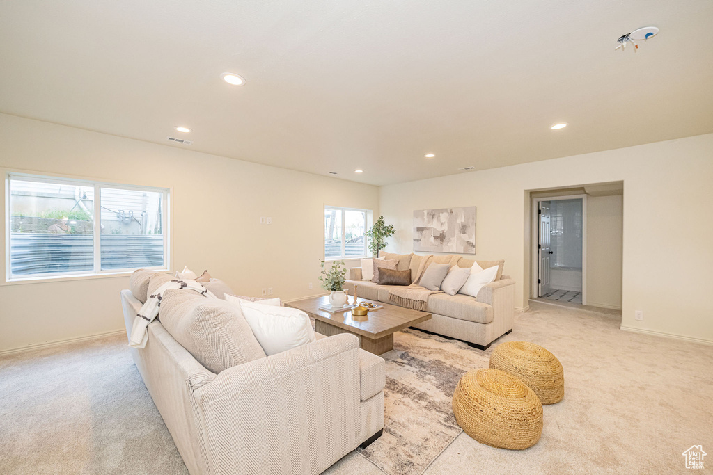 Living room featuring recessed lighting, baseboards, visible vents, and light carpet