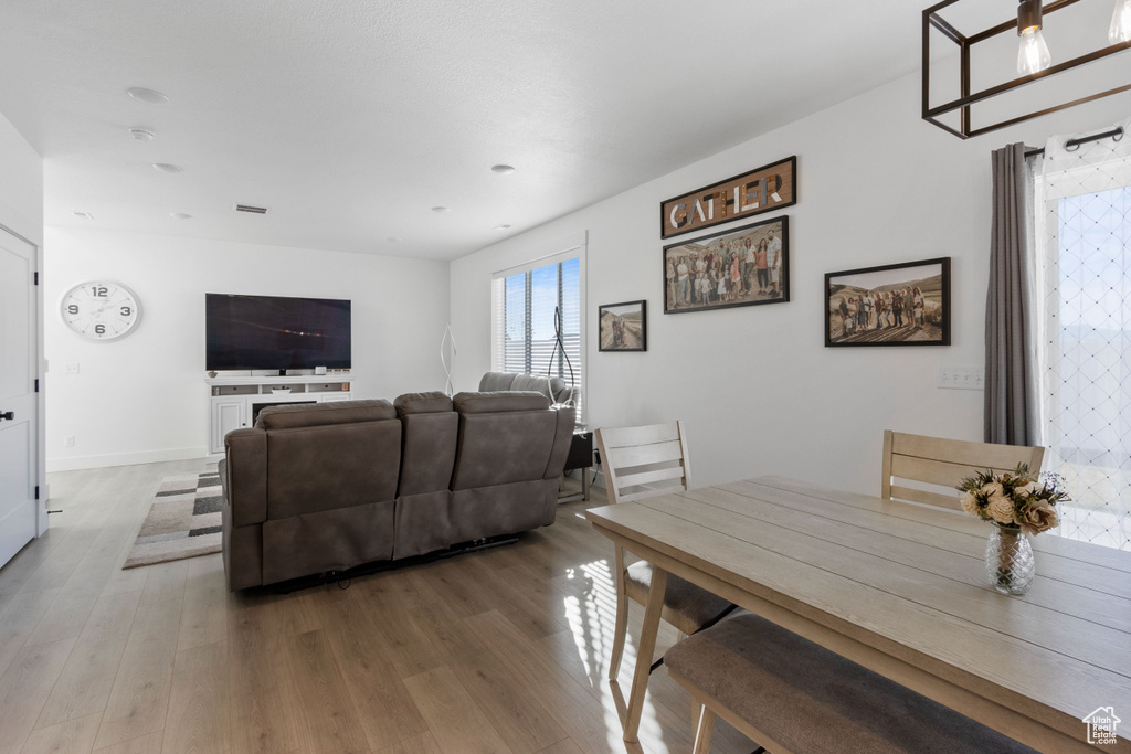 Dining area with visible vents, baseboards, and wood finished floors