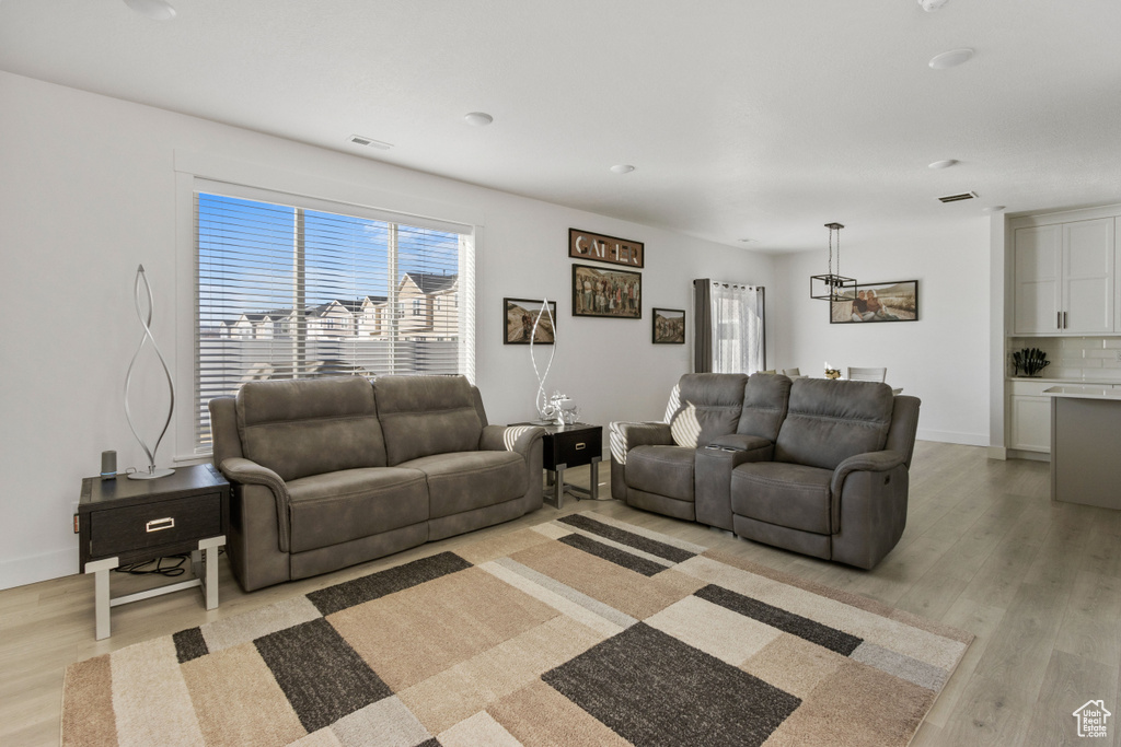 Living area with light wood-style floors, baseboards, and visible vents