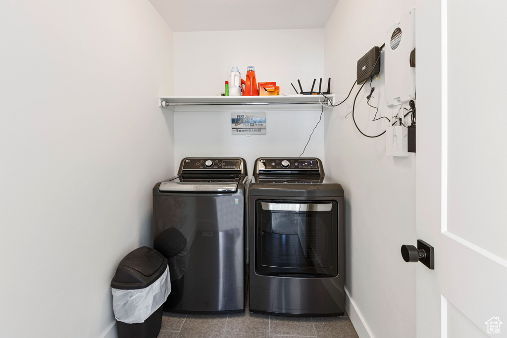 Laundry room with baseboards, laundry area, and washer and clothes dryer