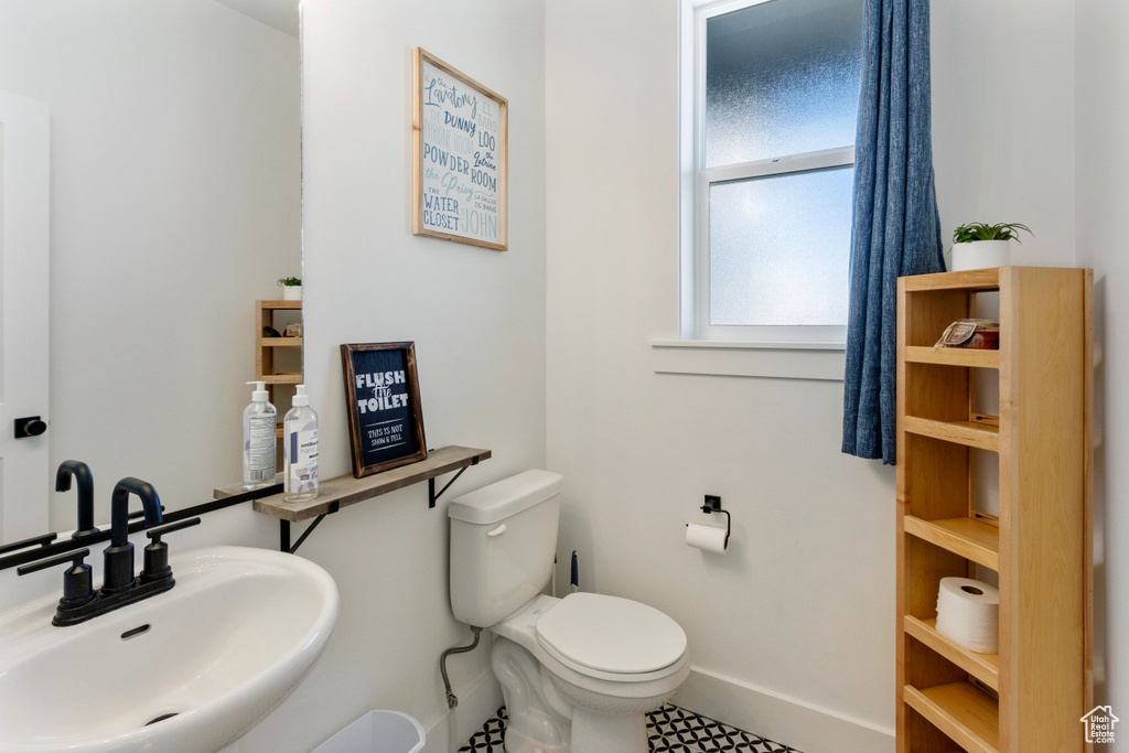 Bathroom featuring a sink, baseboards, and toilet