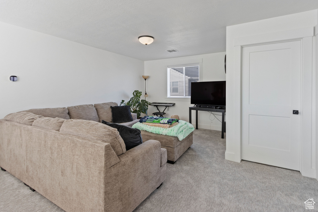 Living room featuring visible vents and light carpet