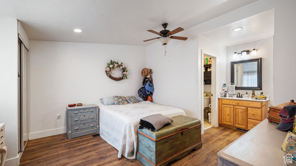 Bedroom with recessed lighting, ceiling fan, ensuite bathroom, a sink, and dark wood-style floors
