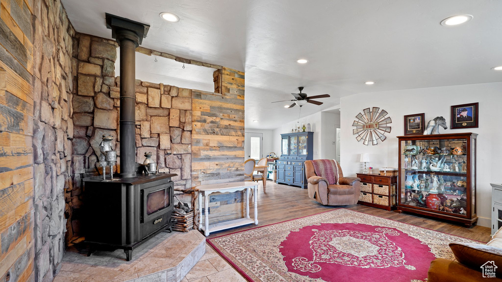 Living area featuring a wood stove, a ceiling fan, recessed lighting, and lofted ceiling