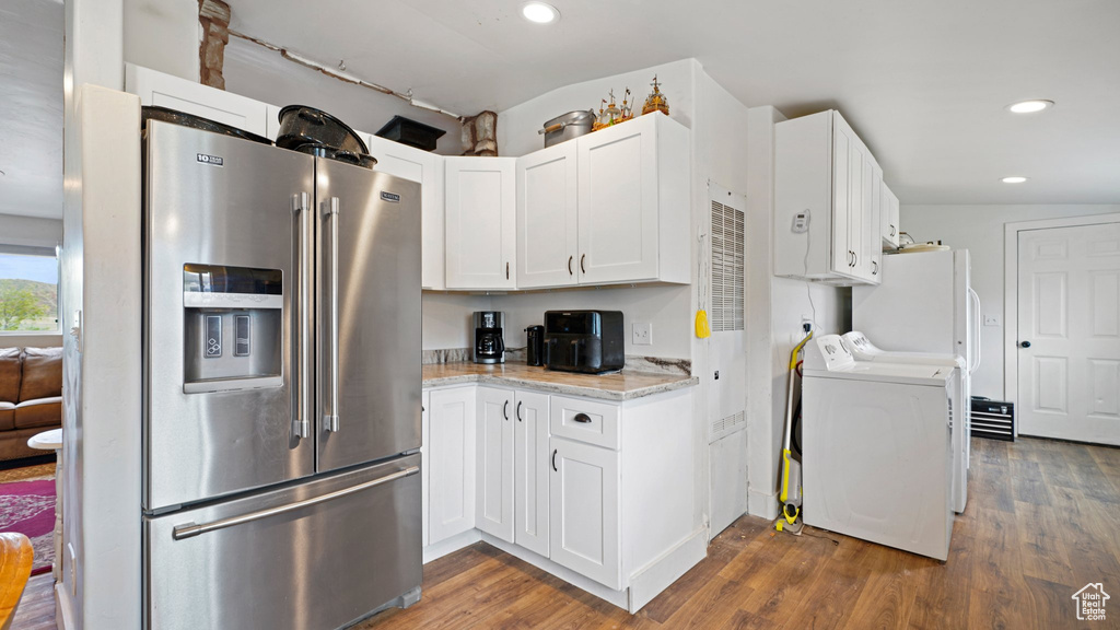 Kitchen featuring dark wood-type flooring, separate washer and dryer, high end fridge, and white cabinets