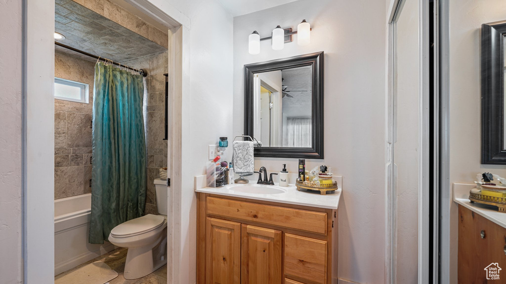 Bathroom featuring toilet, shower / tub combo, and vanity