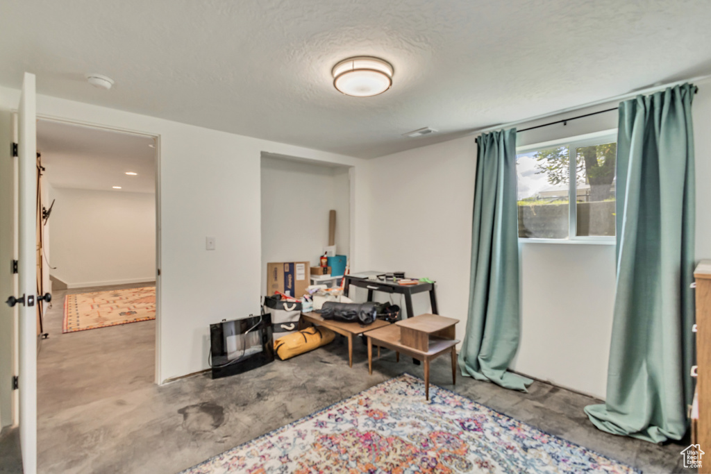 Interior space featuring visible vents, a textured ceiling, and concrete flooring
