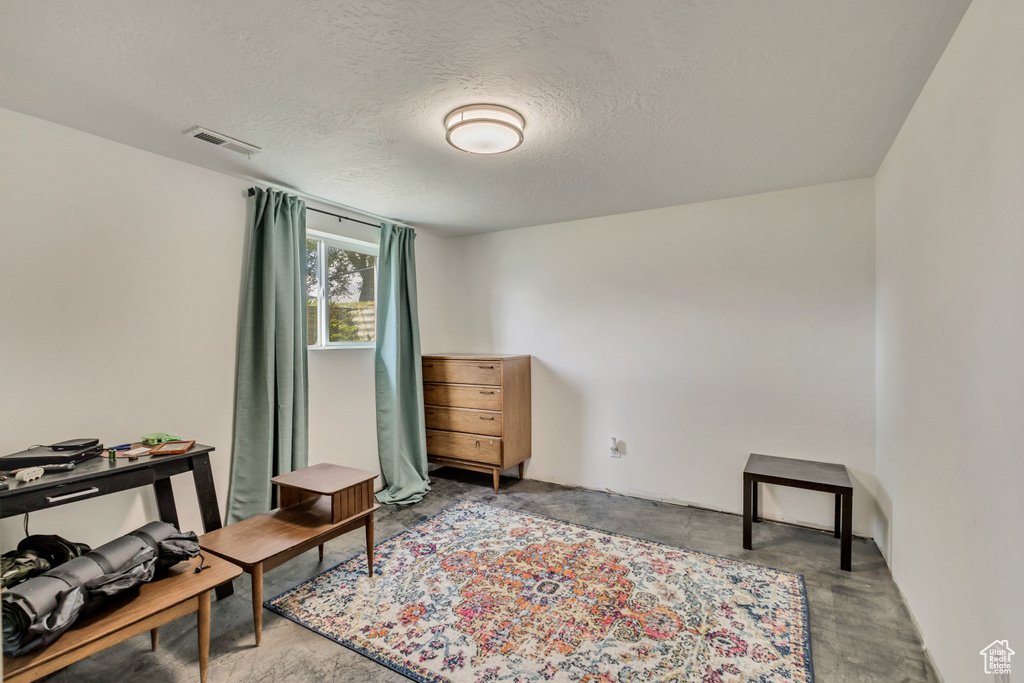 Living area featuring a textured ceiling and visible vents