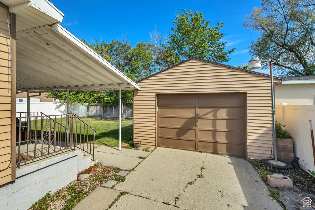 Detached garage with fence and concrete driveway