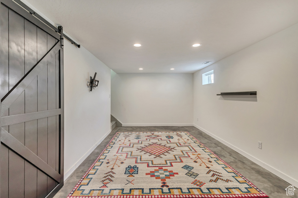 Basement with baseboards, recessed lighting, and a barn door