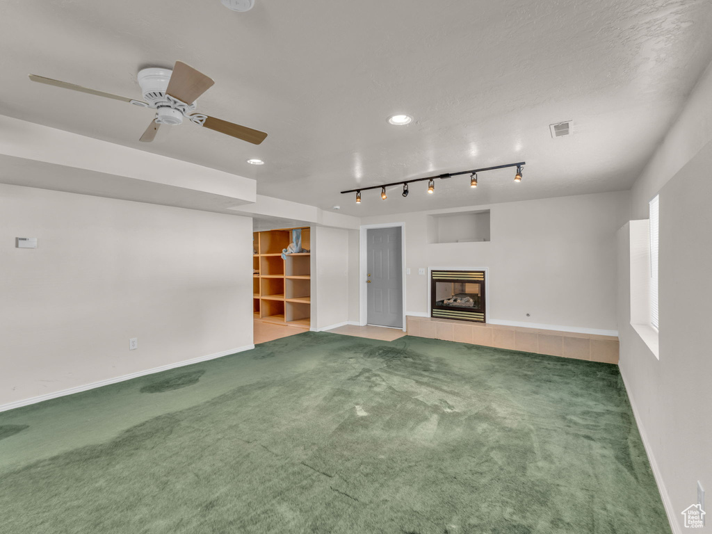 Unfurnished living room featuring ceiling fan, a fireplace, carpet, recessed lighting, and visible vents