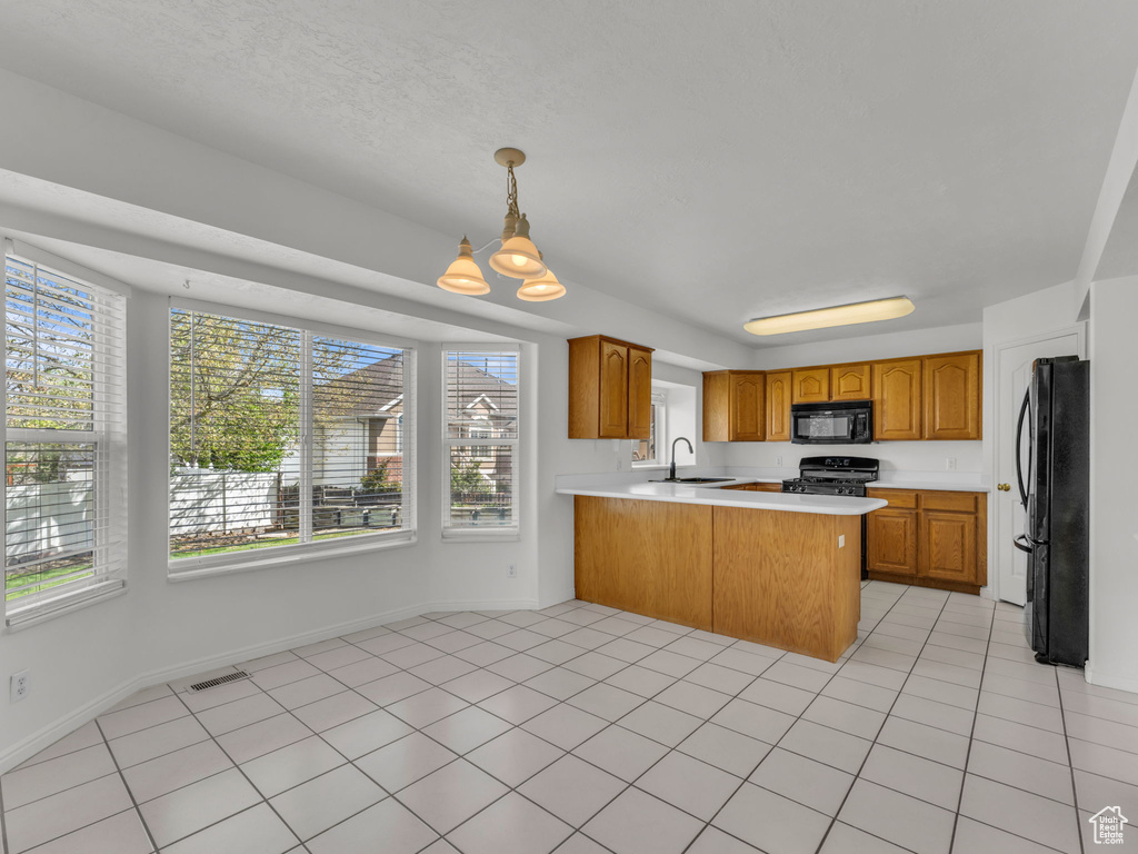 Kitchen featuring visible vents, light countertops, a peninsula, and black appliances