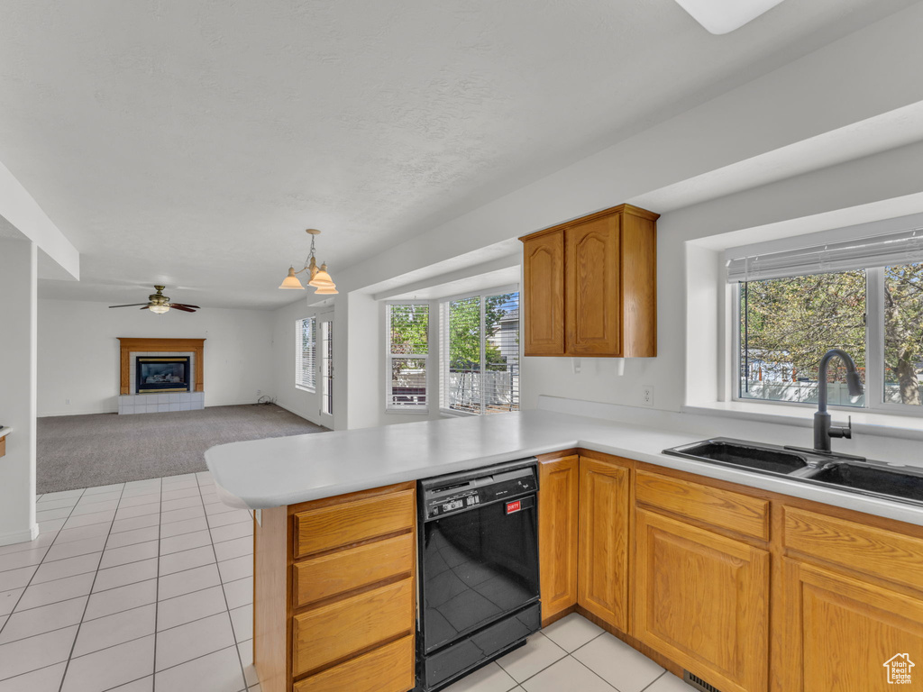 Kitchen featuring a sink, a peninsula, light carpet, black dishwasher, and light tile patterned flooring