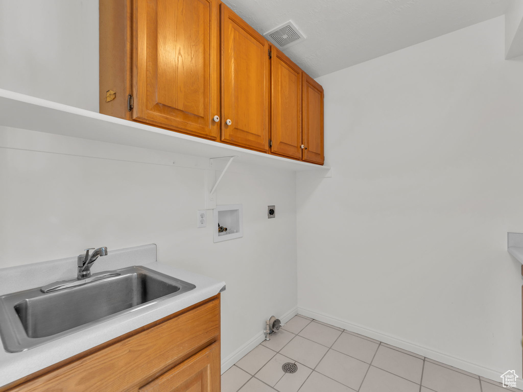 Clothes washing area featuring washer hookup, hookup for an electric dryer, visible vents, cabinet space, and a sink