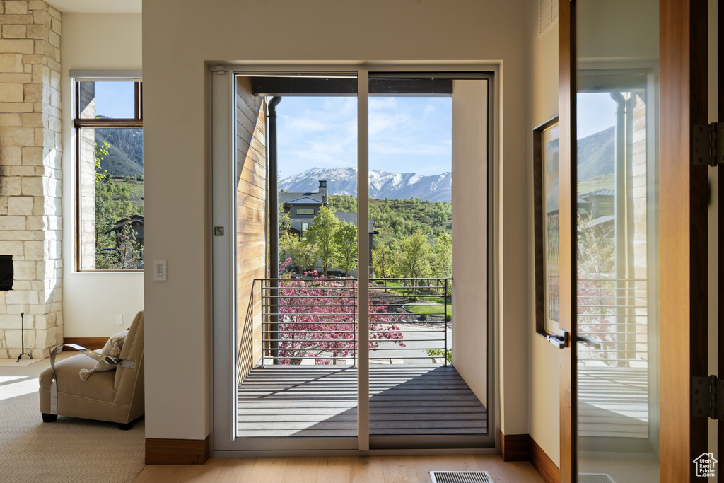 Doorway with a mountain view, plenty of natural light, and baseboards