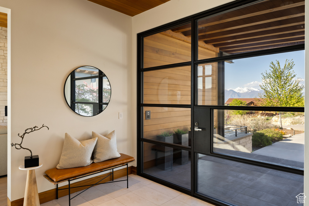 Doorway with tile patterned flooring, a mountain view, and baseboards