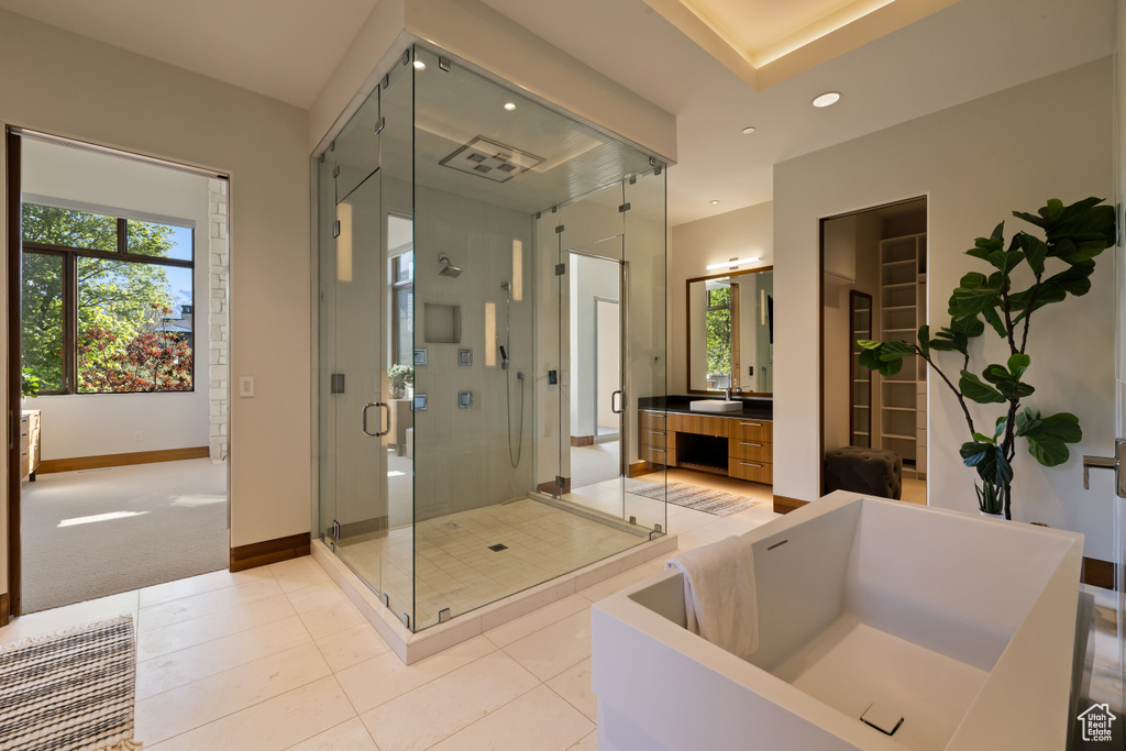 Bathroom with a soaking tub, a stall shower, baseboards, recessed lighting, and tile patterned flooring