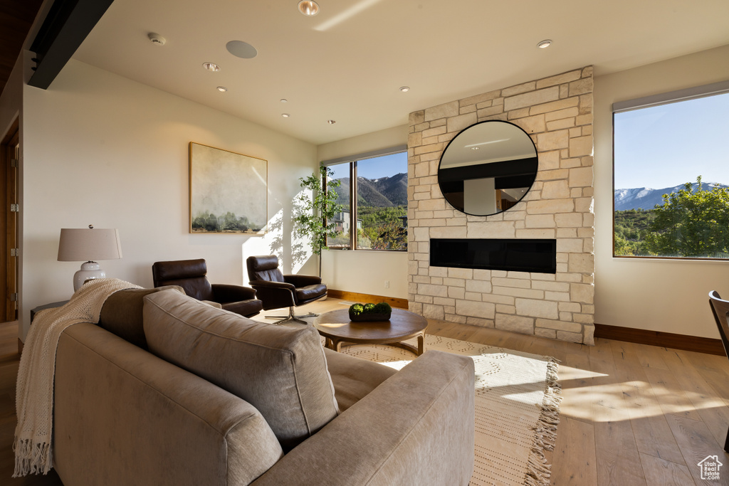 Living room with a mountain view, wood-type flooring, baseboards, a fireplace, and recessed lighting