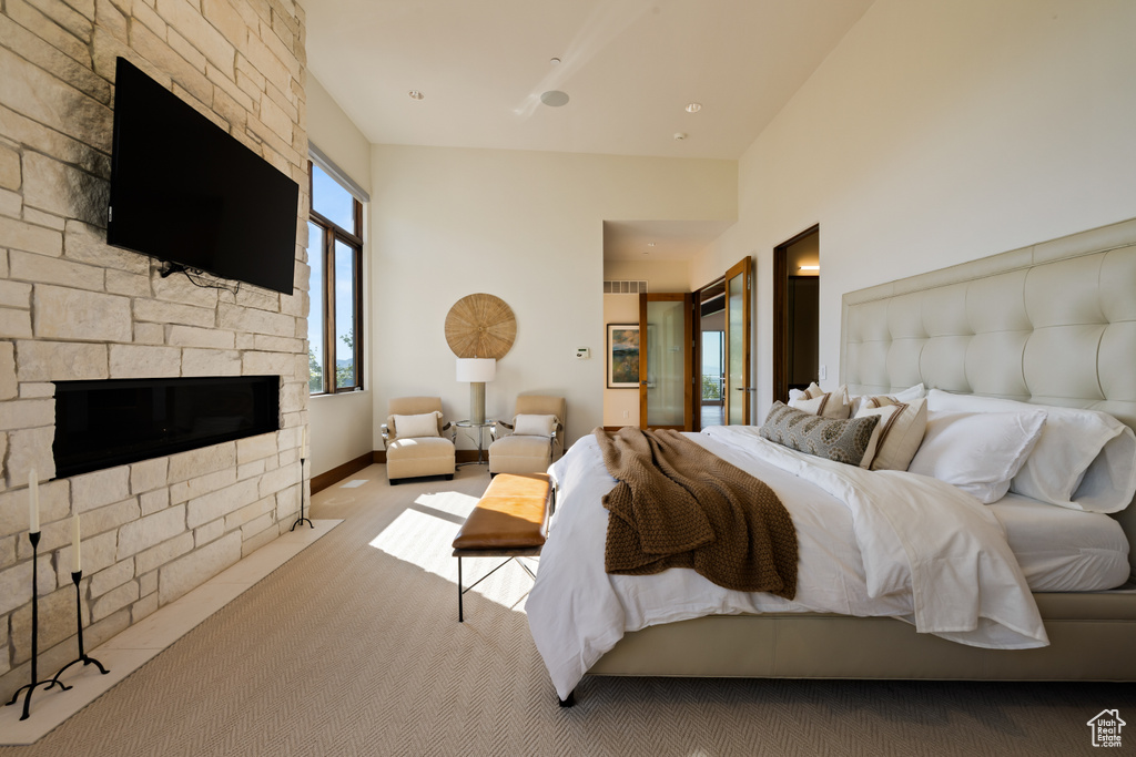 Bedroom featuring carpet flooring, a stone fireplace, and baseboards