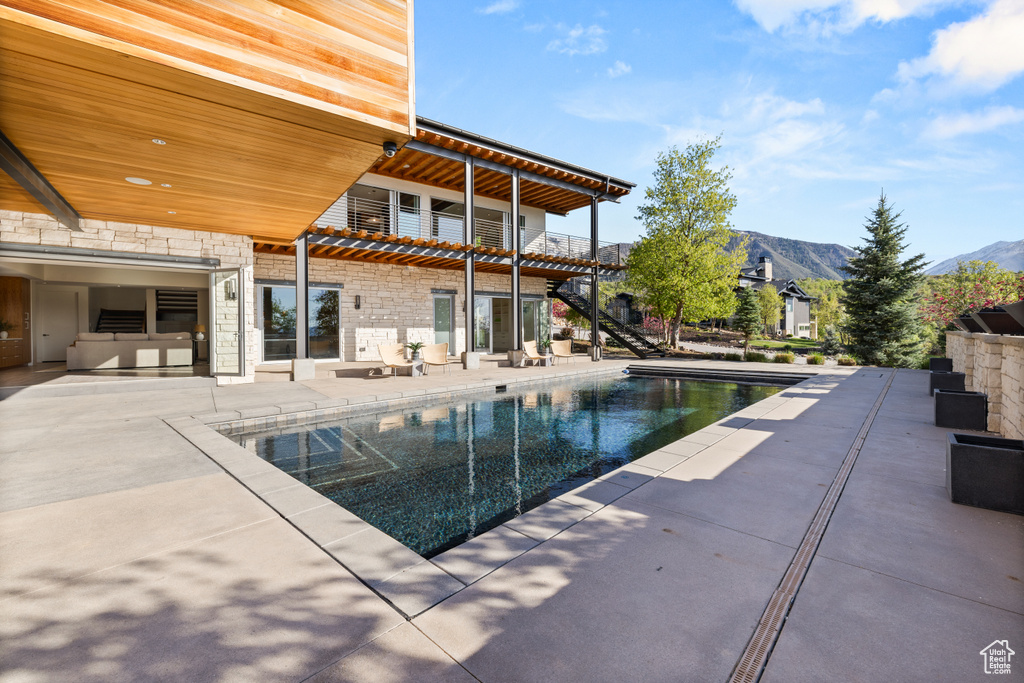 Swimming pool with a patio and a mountain view