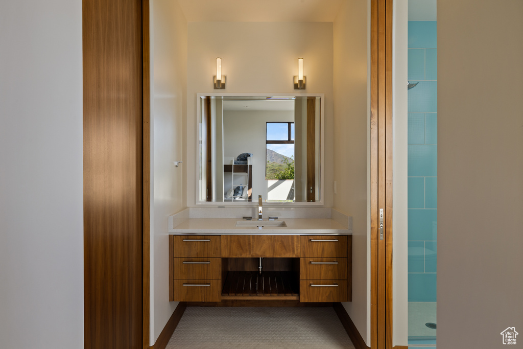 Bathroom with vanity, a shower, and baseboards