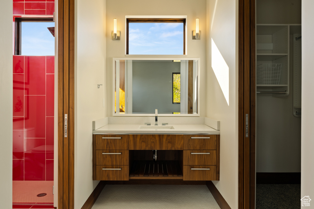 Bathroom featuring a tile shower and vanity