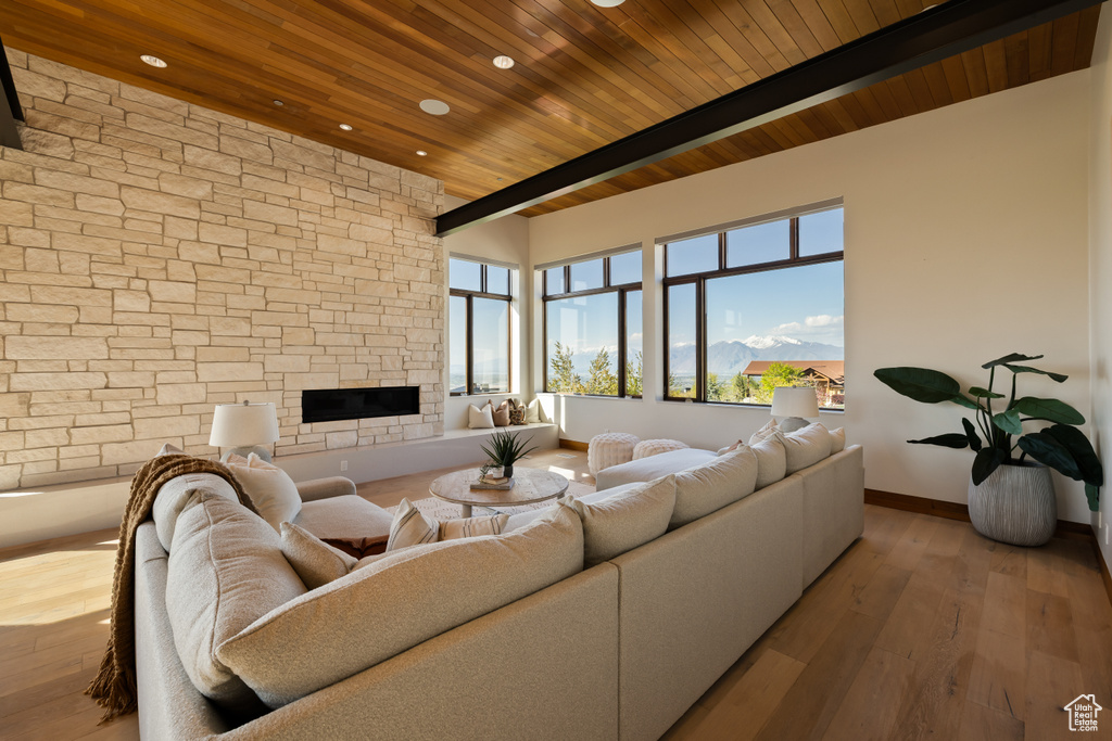 Living room featuring wood ceiling, hardwood / wood-style flooring, baseboards, recessed lighting, and a fireplace